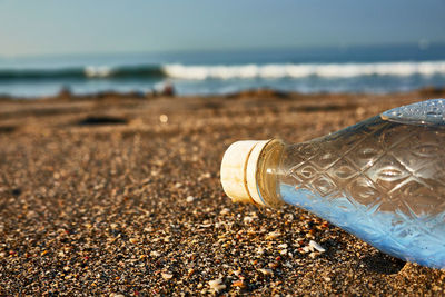 Close-up of water bottle on beach