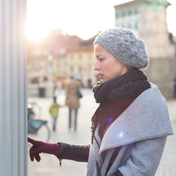 Side view of young woman looking at city in winter