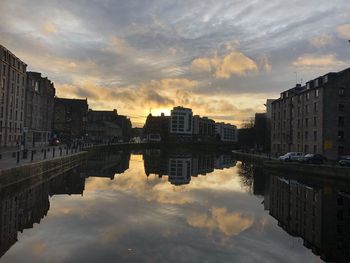 Reflection of buildings in city at sunset