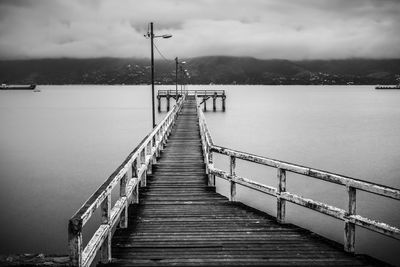 Pier over lake against sky