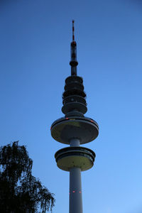 Low angle view of communications tower against blue sky