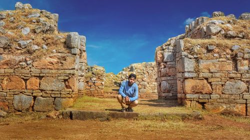 Young man near old ruins