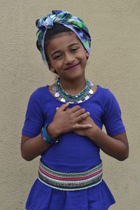 Portrait of smiling girl wearing costume against wall