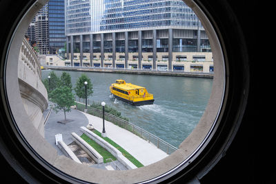 Nautical vessel moving on river seen through window