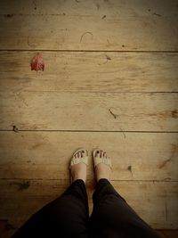 Low section of woman standing on hardwood floor