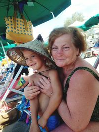 Portrait of happy mother with baby sitting outdoors