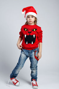 Portrait of boy wearing hat standing against white background