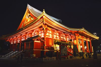 Low angle view of illuminated building against sky at night