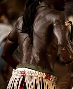 Rear view of shirtless man standing in basket