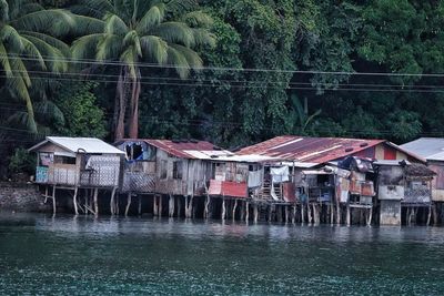 Houses by lake against buildings