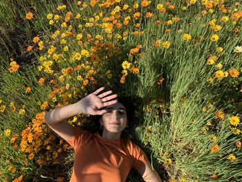 Portrait of woman standing on yellow flowering plants