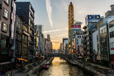 Canal amidst buildings in city against sky