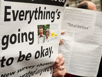 Close-up of hand holding paper with text