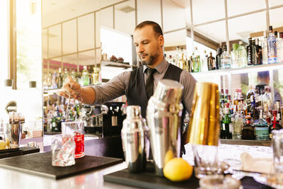 Bartender making drink at bar
