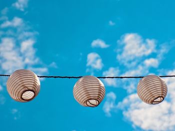 Low angle view of lanterns hanging against sky