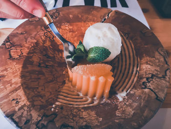 Close-up of hand holding ice cream in plate