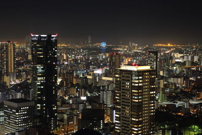 Illuminated cityscape against sky at night