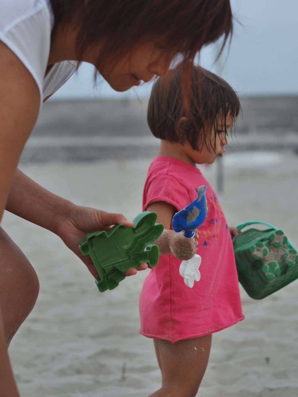 childhood, beach, child, two people, women, water, female, land, family, person, adult, spring, fun, togetherness, toddler, nature, sea, parent, sand, clothing, one parent, holding, emotion, holiday, leisure activity, men, human leg, love, dress, trip, vacation, positive emotion, three quarter length, bonding, casual clothing, summer, day, lifestyles, standing, outdoors, limb