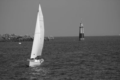 Sailboat sailing in sea against clear sky