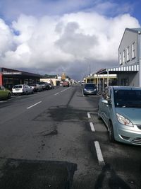 Cars on road in city against sky