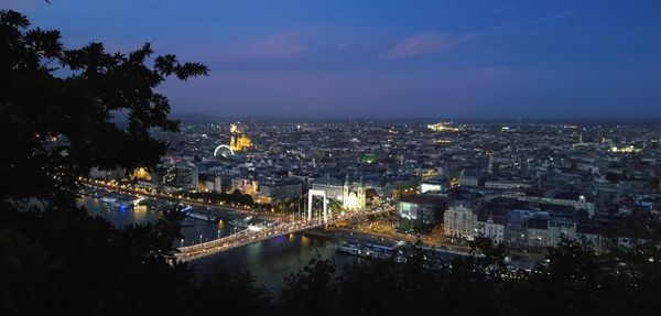 High angle view of illuminated cityscape against sky at dusk