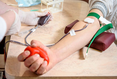 Cropped hands of doctor checking patient blood pressure