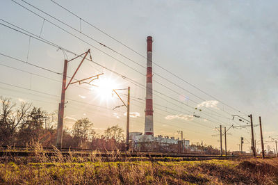 Low angle view of electricity pylon on field against sky