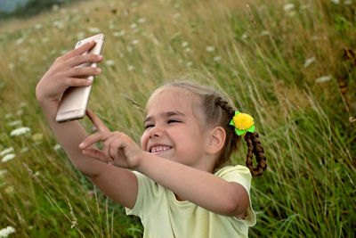 Cute 5-6 years old little girl sharing a photo on social media in internet in the mountains