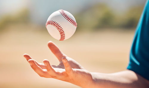 Midsection of woman playing baseball