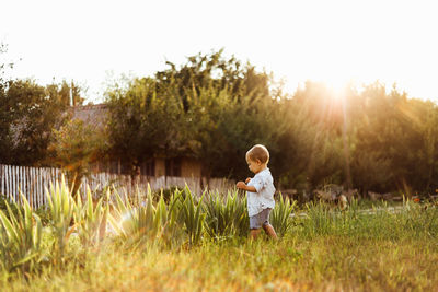 Cute child on field against sky