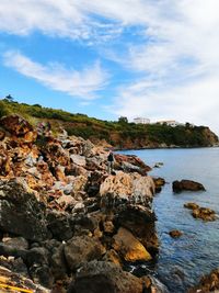 Rocks on sea shore against sky