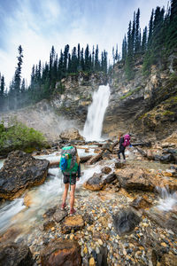 Hikers standing alongside laughing falls waterfall in yoho