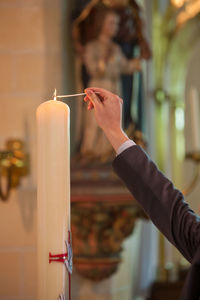 Cropped hand of woman holding candle