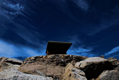 Low angle view of rocks against blue sky