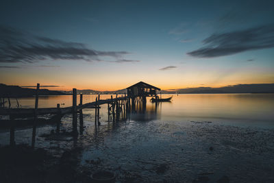 Pier over sea against sky during sunset