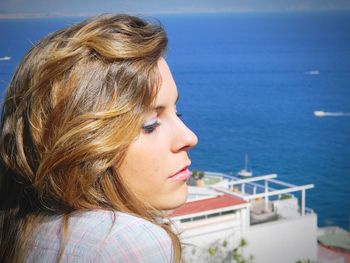Side view of thoughtful woman against sea