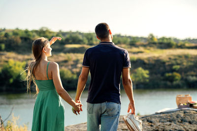 Cheap vacations for couples, candid couple in love holding hands on nature background.