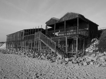 Traditional windmill on beach against sky