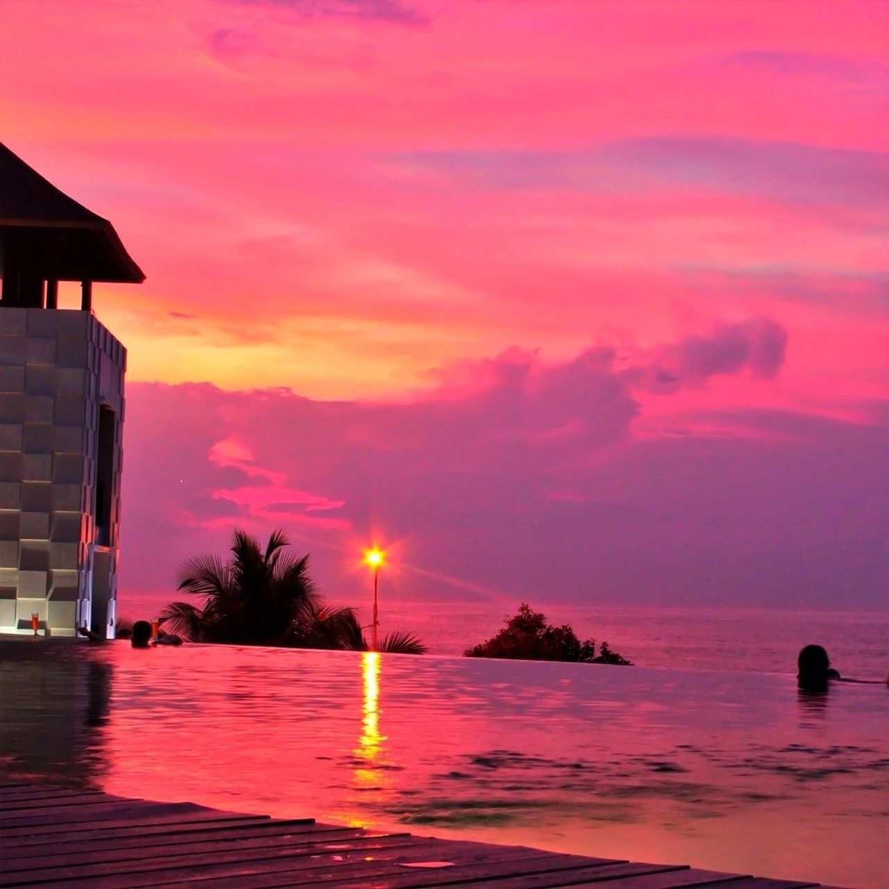 sunset, water, sky, sea, waterfront, orange color, built structure, building exterior, scenics, cloud - sky, reflection, tranquil scene, beauty in nature, architecture, tranquility, horizon over water, sun, idyllic, red, cloud