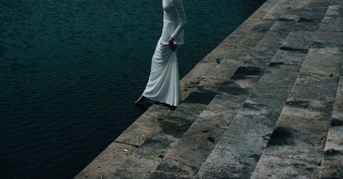 Low section of woman standing on cobblestone