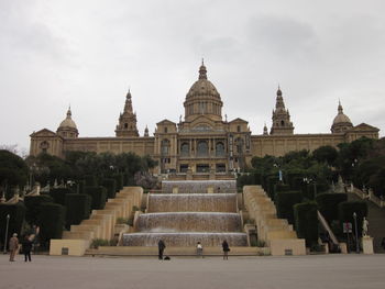 Group of people in front of museu nacional d art de catalunya against sky