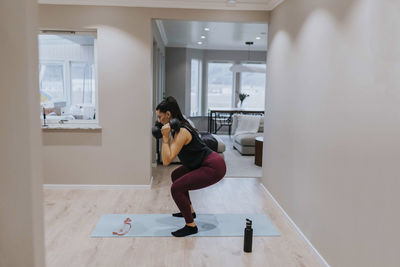 View of woman exercising at home