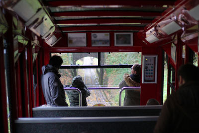 Rear view of people standing in train