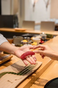 Cropped hand of person preparing food on table