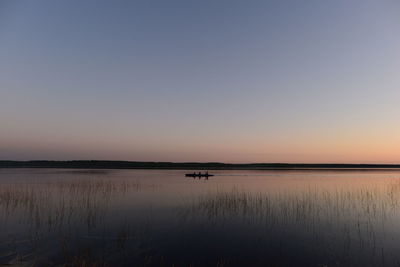 Scenic view of lake against clear sky during sunset