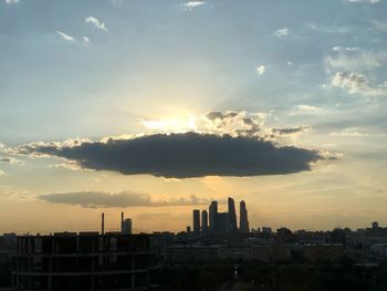 Buildings in city against sky during sunset