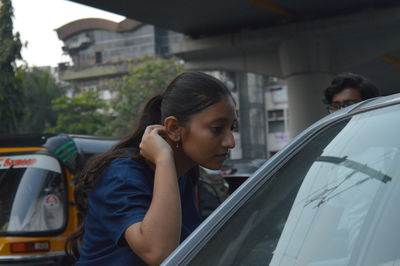 Side view of young woman in car
