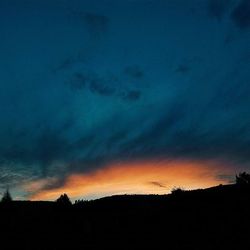 Silhouette of landscape against cloudy sky