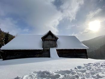 Built structure on snow covered land against sky