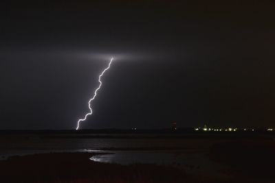 Lightning over sea against sky at night